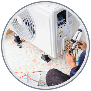 AC & Heating Tune-Up Special 4 HVAC technician using a tool to clean an air conditioning drain line and performing an AC Repair Service.