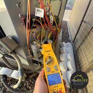 A technician using a multimeter to diagnose an aging air conditioning unit, highlighting the importance of considering an AC upgrade for older systems | AC Repair Apache Junction