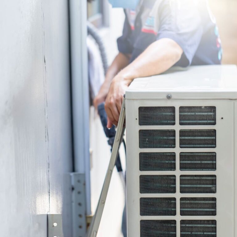 A technician inspecting an outdoor air conditioning unit, highlighting the importance of professional Heating Repair Services in Gilbert to maintain optimal system performance.