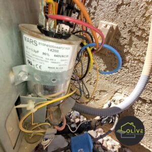 Close-up of a faulty HVAC capacitor with tangled wires, highlighting the importance of Mesa HVAC repair and maintenance for optimal AC performance.
